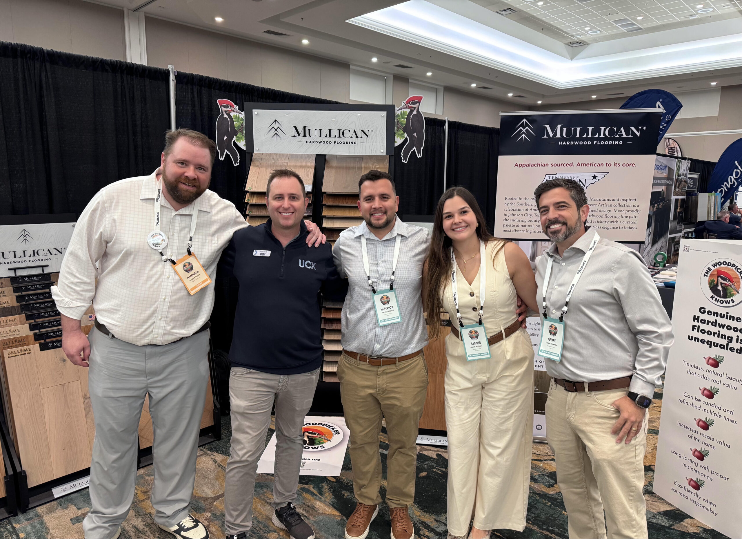 Five flooring professionals at the Mullican Hardwood Flooring booth during an industry trade show.